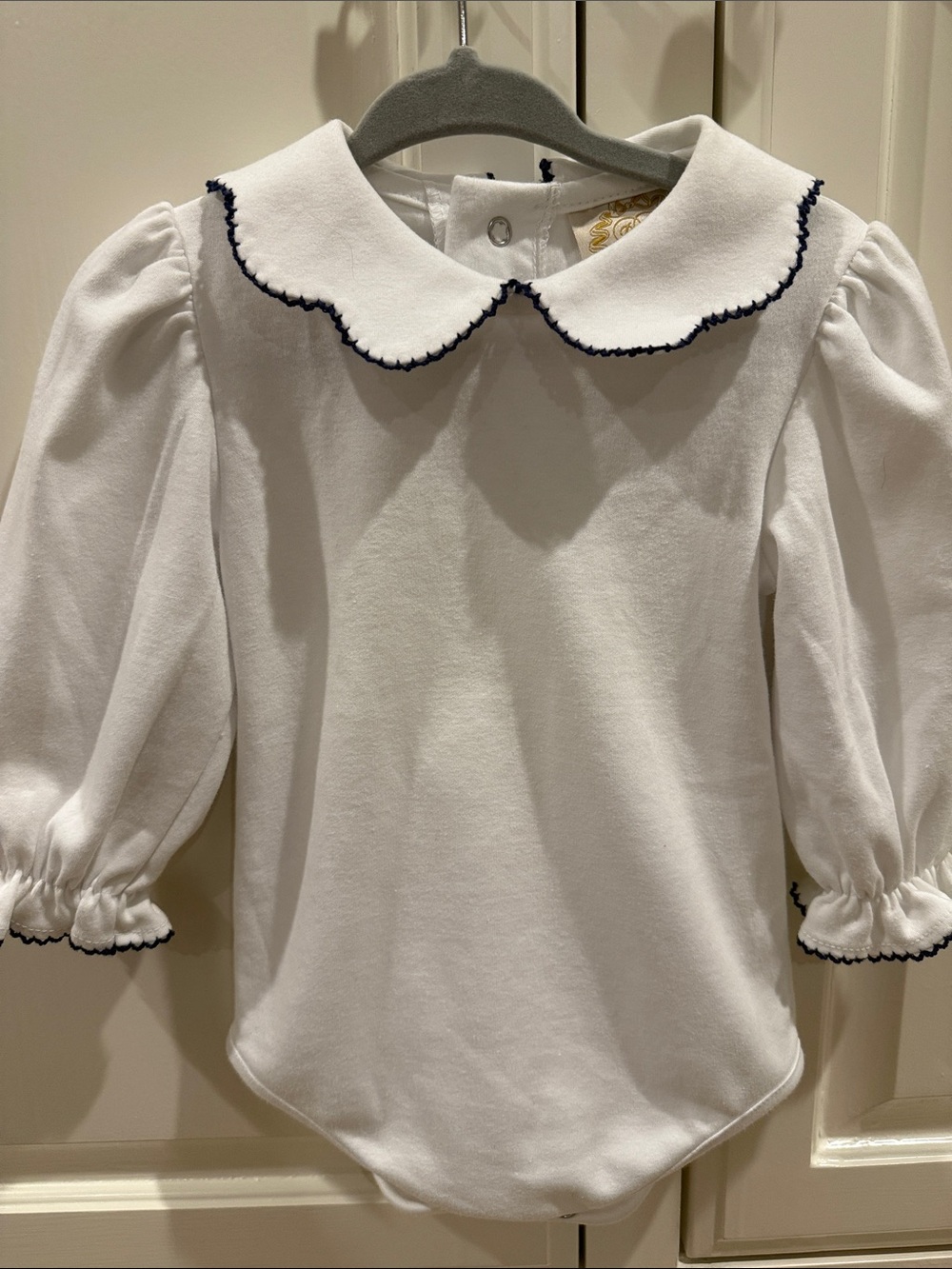 The Beaufort Bonnet Company White Bodysuit with Bow Embroidery and Navy Trim